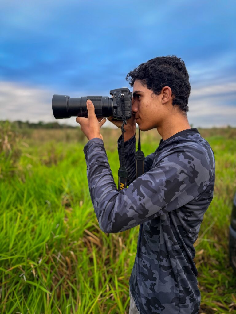 Aluno fotografando aves em saída de campo do curso de condutores de observação de aves