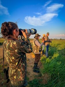 Grupo do curso de condutores observando aves sob céu azul nas várzeas do Ivinhema