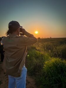 Observador de aves com binóculo ao nascer do sol nas várzeas do Rio Ivinhema