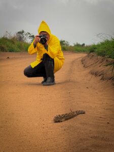 Participante fotografando rastro de animal na estrada de terra durante o curso