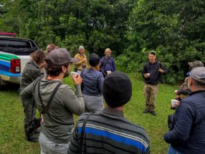 Instrutor orientando a turma em saída de campo de observação de aves